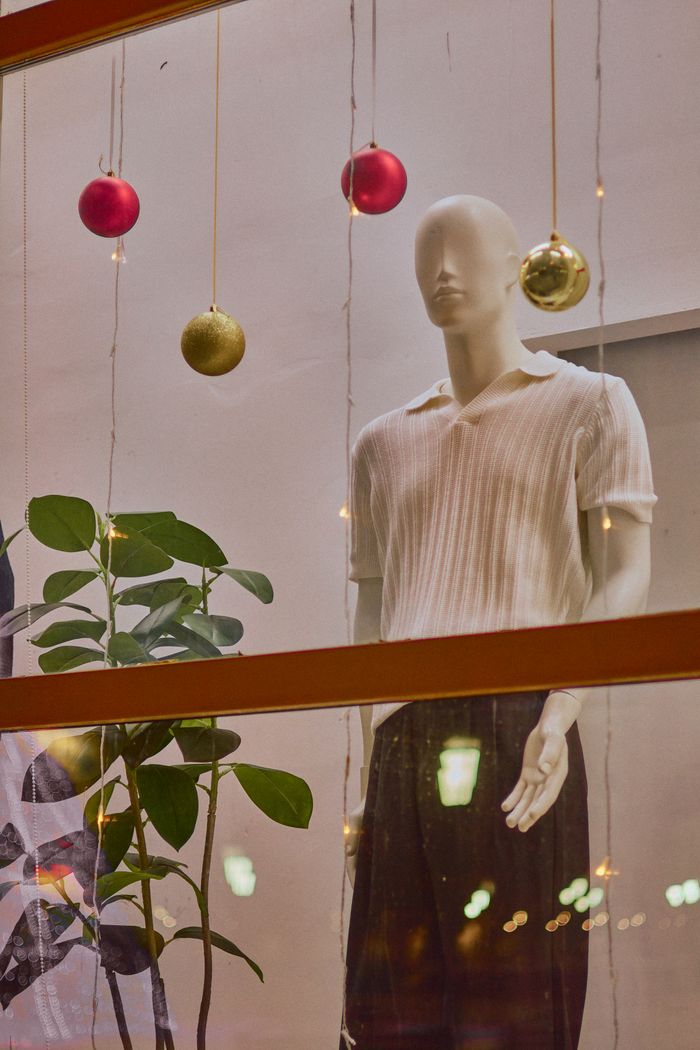 why-choose-us A festive window display featuring a mannequin and Christmas ornaments.