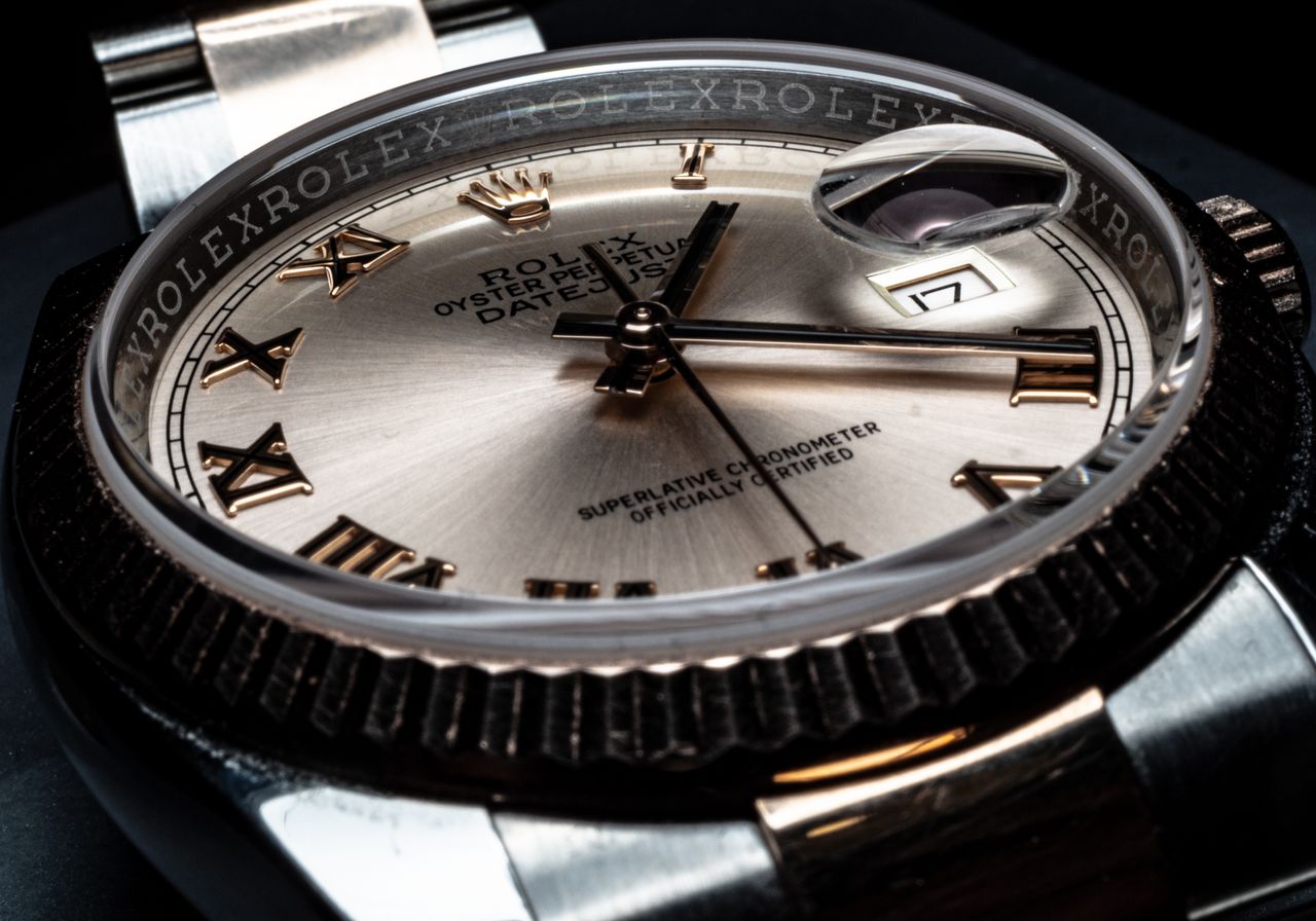 gallery-4 Detailed close-up of a luxury Rolex wristwatch displaying its elegant design and date feature.