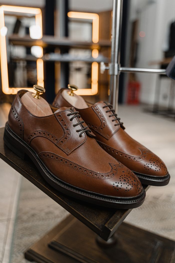 services-04 Pair of classic brown leather brogue shoes showcased in a stylish setting.